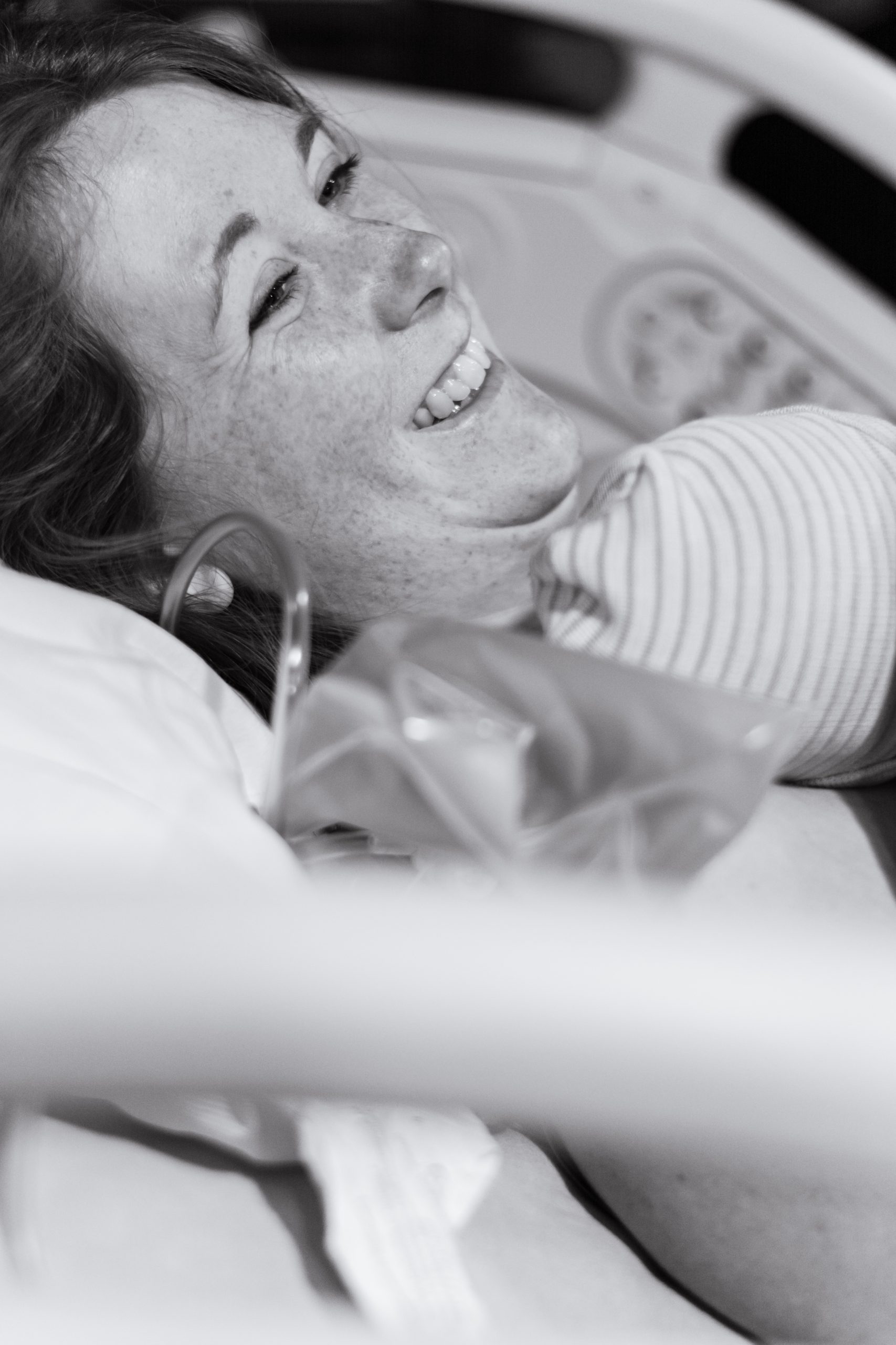 mother holding newborn baby smiling