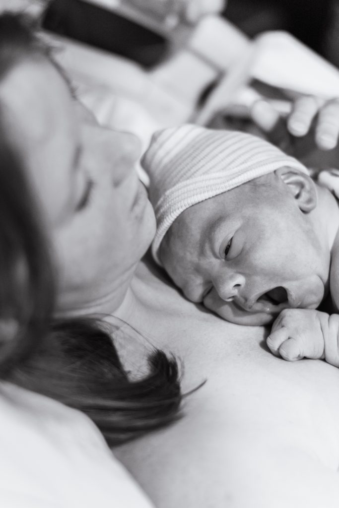 newborn baby laying on mother's chest