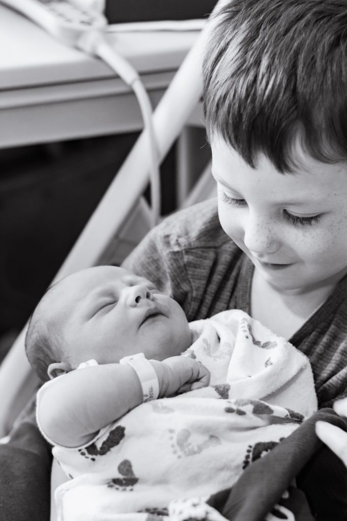 brother holding newborn baby