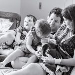 sister kissing newborn baby