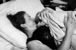 mom smiling at newborn baby